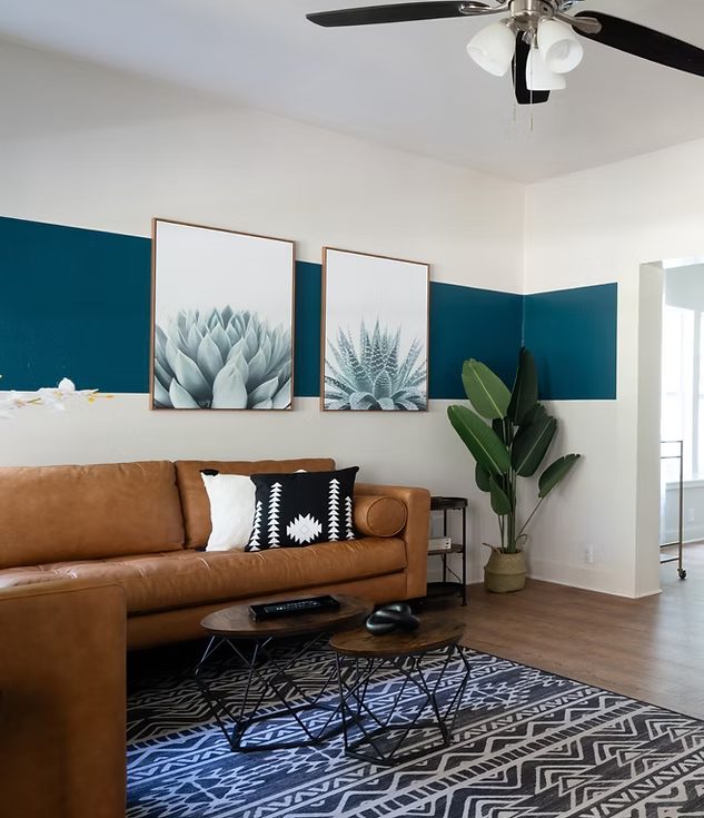 Modern short-term rental living room with teal walls, cognac leather chair, and curated art — Craft design package