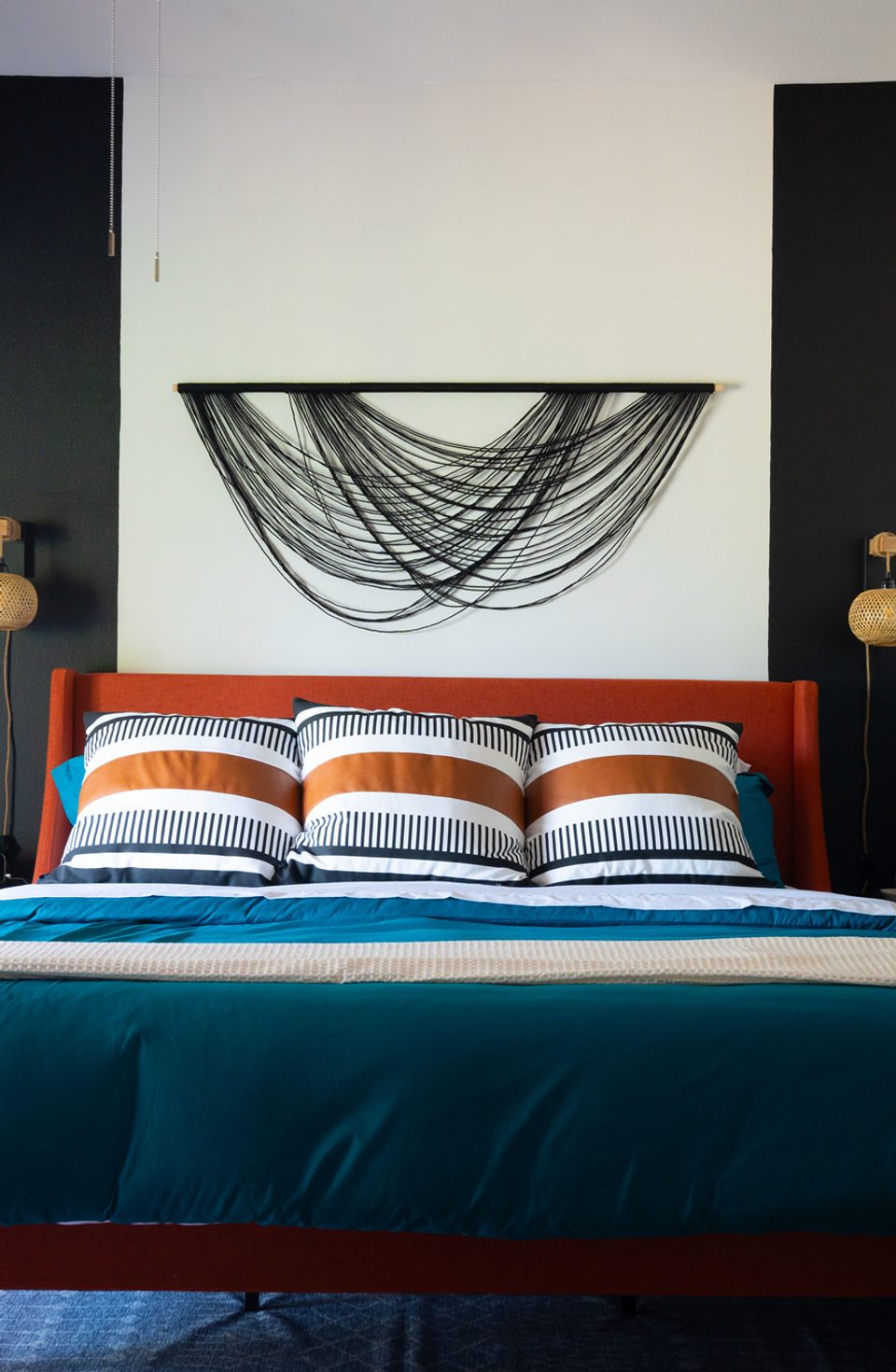 Short-term rental bedroom with custom upholstered headboard and layered bedding — Vision design package